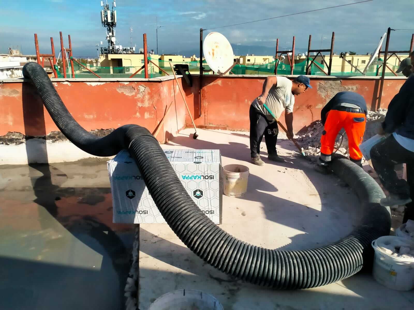 Squadra al lavoro con il tubo di aspirazione su una copertura