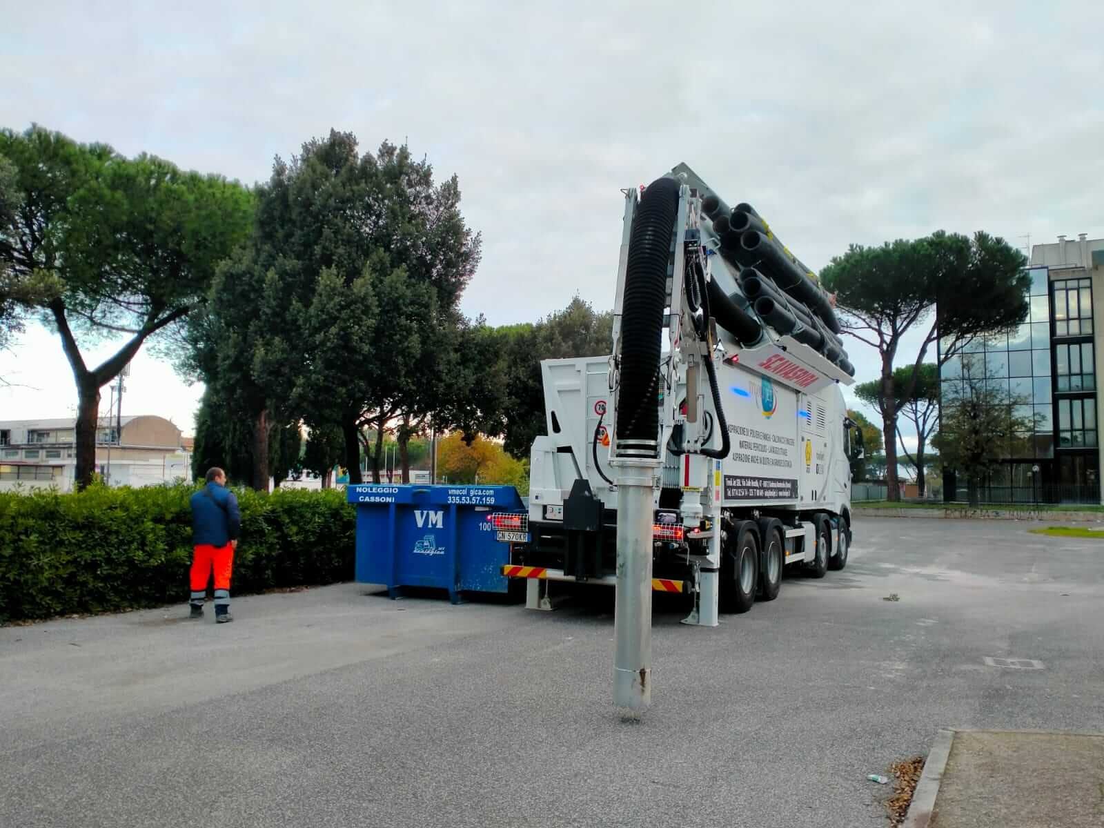 Automezzo per l'aspirazione accanto ai cassoni scarrabili