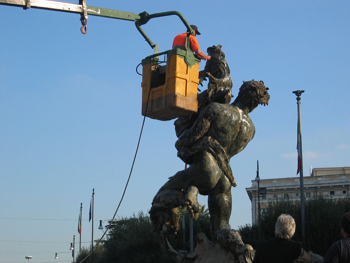 Operatore su cestello elevatore durante la pulizia di una fontana monumentale